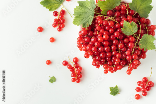 Red currant berries with green leaves isolated on the white background. Fresh summer berries