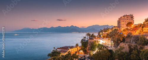 Fototapeta Naklejka Na Ścianę i Meble -  Aerial panoramic cityscape view of Antalya resort town with hotels and buildings and Taurus mountains in the background during majestic sunset twilight