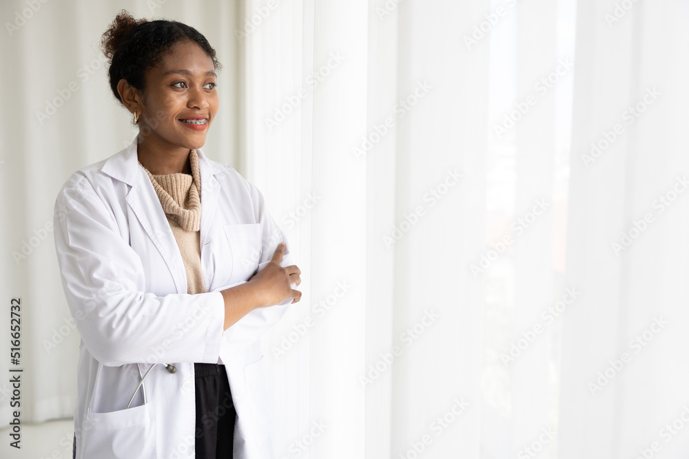 African doctor folded arms pose smiling and looking to something on white background African doctor folded arms pose smiling and looking to something on white background