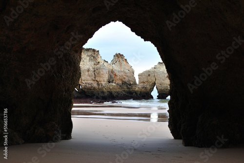 View through Cave in Cliff to Sandy Beach and Rocks 