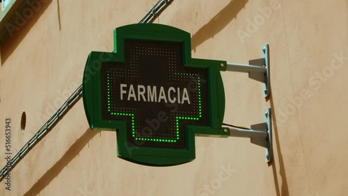 A flashing, green, LED cross as a symbol of a pharmacy, helping the sick and the needy. The concept of medicines, pandemics, rising drug prices, the quality of pharmacy products.