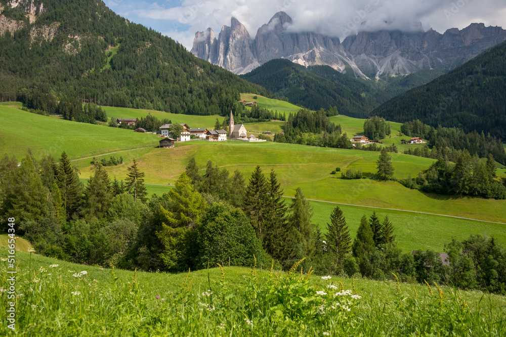 Paisaje rural con las casas e iglesia de Santa Maddalena Alta en el Valle de Funes en la provincia de Bolzano, Italia