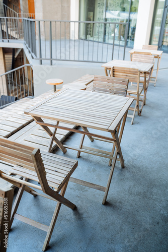 Outdoor cafe with wooden tables  wooden furniture  folding garden furniture  city catering place  have a snack at the table.