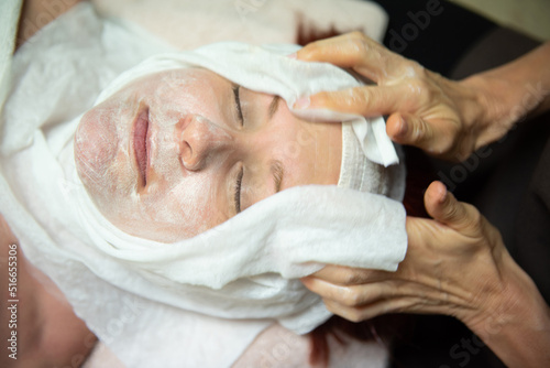 Mature woman with green eyes receiving a facial treatment