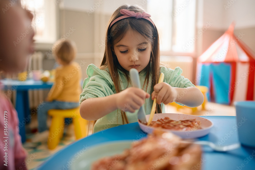 Little girl eats lunch at kindergarten. Little girl eats lunch at kindergarten.