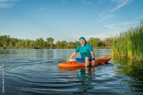 athletic, senior man is paddling a prone kayak on a lake in Colorado, this water sport combines aspects of kayaking and swimming © MarekPhotoDesign.com