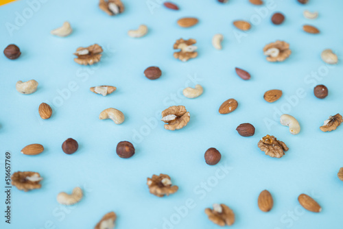nuts mix for a healthy diet cashew, peanut, hazelnuts, walnuts, almonds on blue background