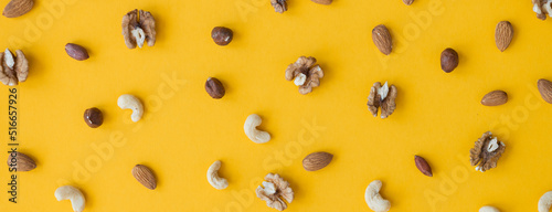Organic mixed nuts on yellow background, top view
