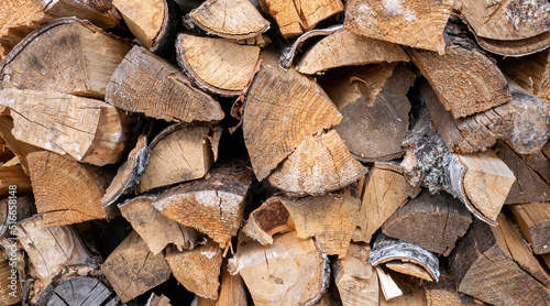 Harvesting firewood for the winter. A supply of firewood for heating the house in winter. Stacked firewood close-up.