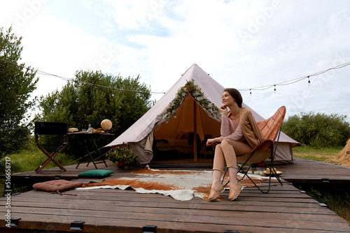 a pretty young lady at the nature next to the glamping tent