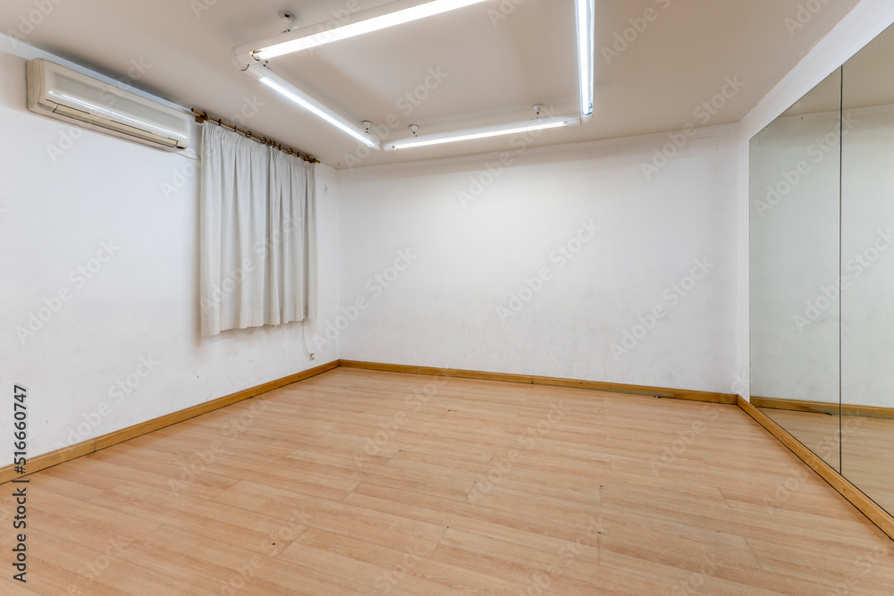 Fototapeta premium Exercise room with hardwood floors and a mirrored wall