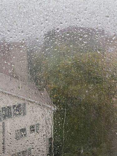Closeup - heavy rain drops on the window and screen during hurricane 