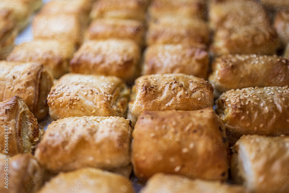 A variety of bread products with sesame: buns, pretzels, poppy seed buns for sale in a bakery A variety of bread products with sesame: buns, pretzels, poppy seed buns for sale in a bakery
