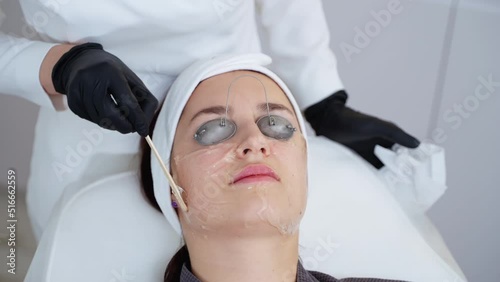 Beautician applying cooling gel before photofacial treatment photo