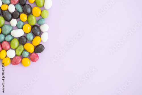 Top view of colorful sweets on violet background with copy space.