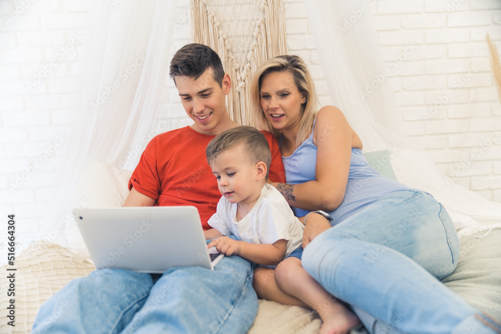 happy Caucasian family with kid son enjoying by using laptop at the home medium full shot. High quality photo happy Caucasian family with kid son enjoying by using laptop at the home medium full shot. High quality photo