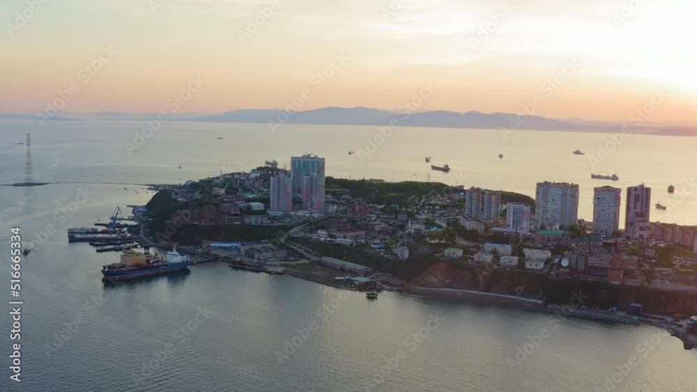 The beautiful peninsula of Shkota (Egersheld) in the rays of the setting sun. Port container terminal, Amur Bay, panoramic view from a drone. Flight over Vladivostok. Russia The beautiful peninsula of Shkota (Egersheld) in the rays of the setting sun. Port container terminal, Amur Bay, panoramic view from a drone. Flight over Vladivostok. Russia