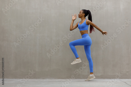 Fit woman exercising outdoors. Healthy young female athlete doing fitness workout.