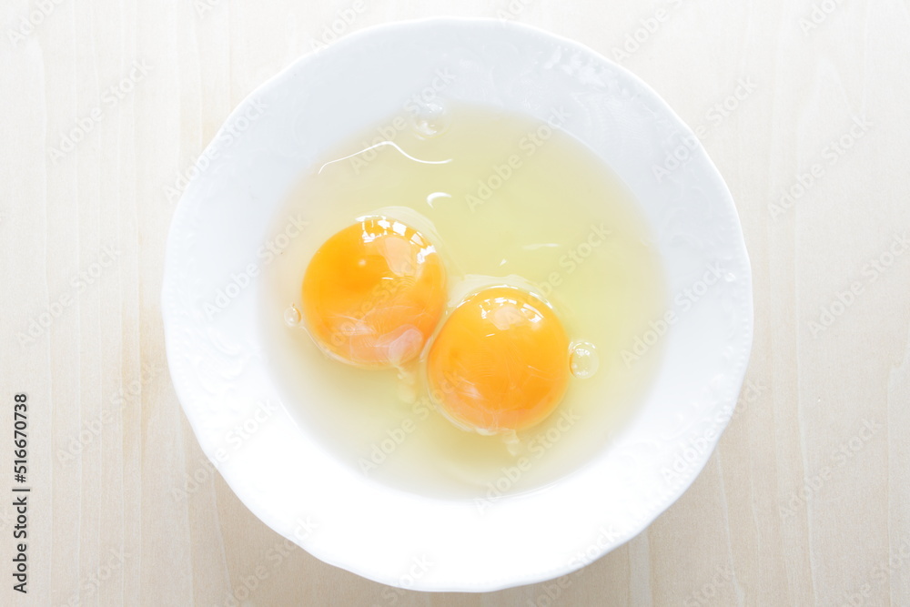 Double raw egg in white bowl with copy space Double raw egg in white bowl with copy space