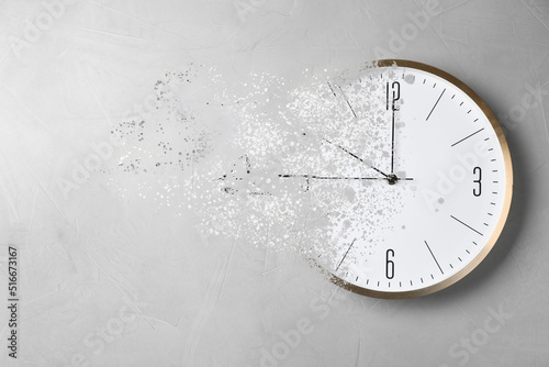 Time is running out. Clock vanishing on light background photo