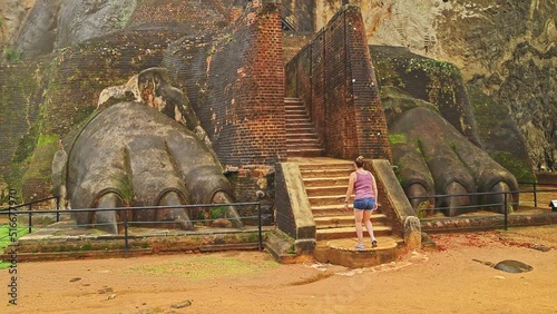 Caucasian female tourist hiking up the stairs of Lion's Paw which leads to the Lion's Rock Fortress in Sigiriya, Sri Lanka