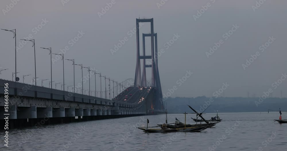 fishing boats passing by in the Java sea with the background of the Suramadu bridge that connects the island of East Java with the island of Madura fishing boats passing by in the Java sea with the background of the Suramadu bridge that connects the island of East Java with the island of Madura