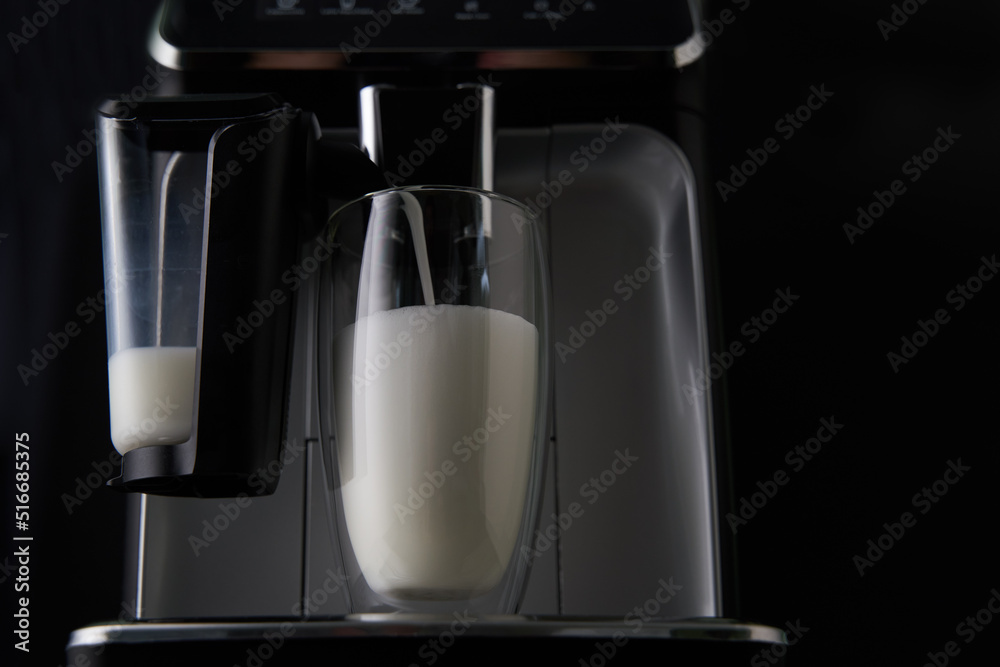 Freshly brewed latte is poured from the coffee machine into glass cups. Freshly brewed latte is poured from the coffee machine into glass cups.