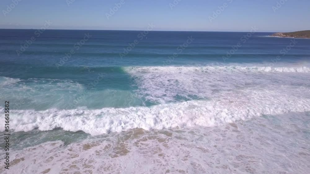Aerial view of ocean waves crashing the shore. Drone flying sideways Aerial view of ocean waves crashing the shore. Drone flying sideways