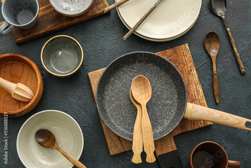 Kitchen utensils and dinnerware on dark background