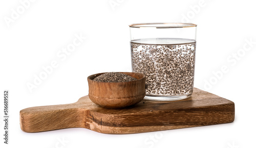 Wooden board with glass of water and chia seeds on white background photo