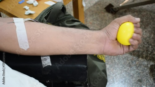 Blood donor at Blood donation camp held with a bouncy ball holding in hand at Balaji Temple, Vivek Vihar, Delhi, India. Also concept image for World blood donor day on June 14 every year photo