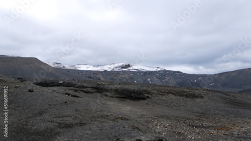 Snow capped hill above a volcanic landscape at Telefon Bay, Deception Island, Antarctica