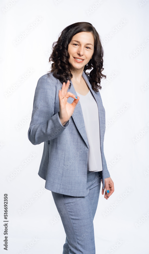 business woman in a gray trouser suit. Woman with long curly hair. Isolated, white background business woman in a gray trouser suit. Woman with long curly hair. Isolated, white background