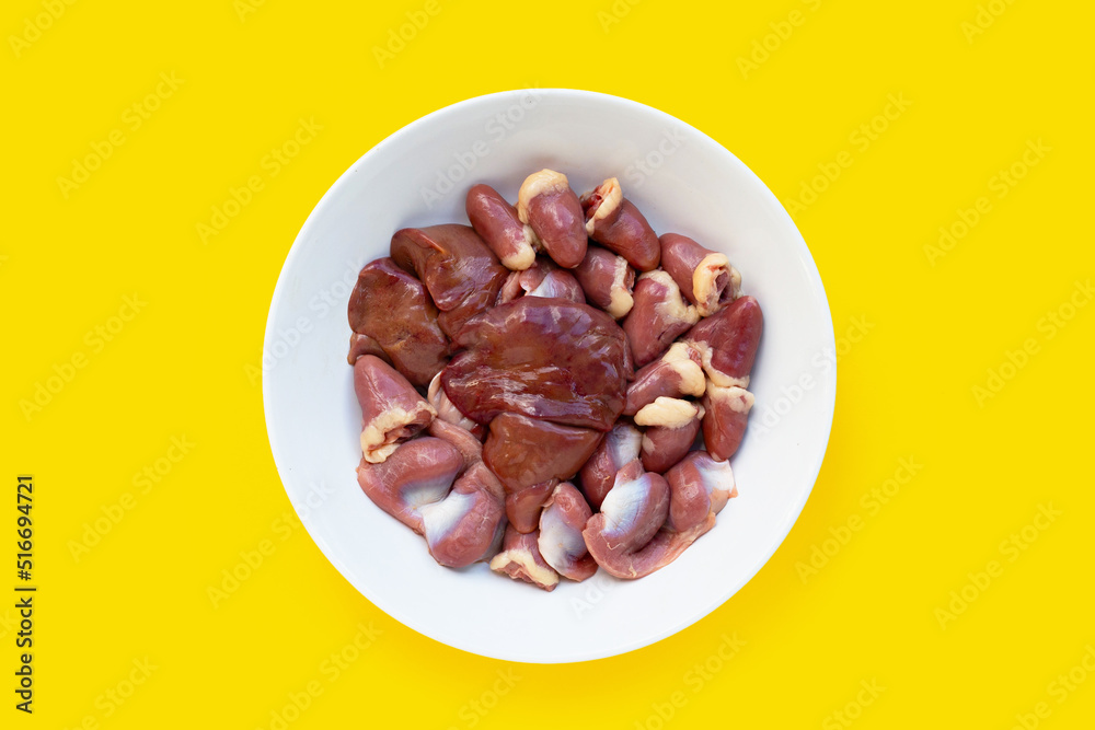 Mixed chicken entrails in white plate on yellow background. Mixed chicken entrails in white plate on yellow background.