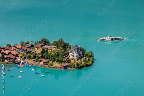 High view over the village of Iseltwald at the turquoise Brienz Lake with a tour ship on the lake, Switzerland. photo