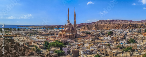 Widescreen panorama of the Old Market in Sharm El Sheikh with the Al Sahaba Mosque in the center and the Red Sea on the horizon. Aerial view of an Egyptian resort photo
