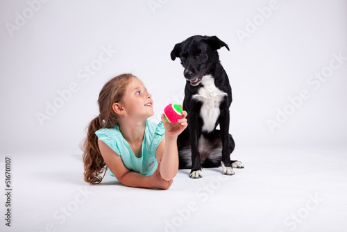 Cute little girl with her best pet friend black female dog on white backround.