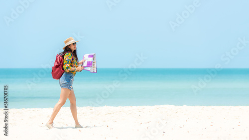 Happy traveler and tourism women travel summer on the beach.  Asian smiling people holding map and camera planning travel trip and relax outdoor for destination and leisure