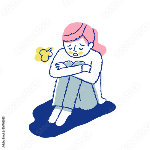 膝を抱えて落ち込んでいる女性