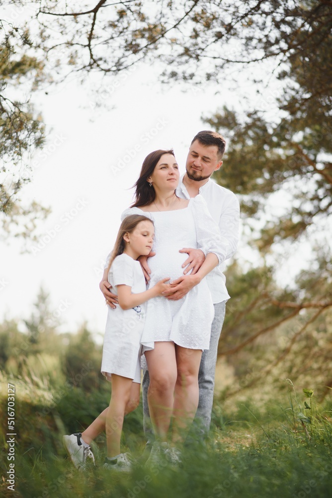 Fototapeta premium Pregnant woman with her family looking happy