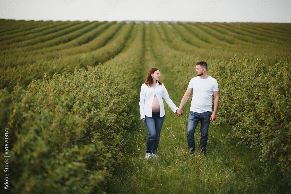 Happy and young pregnant couple hugging in nature Happy and young pregnant couple hugging in nature