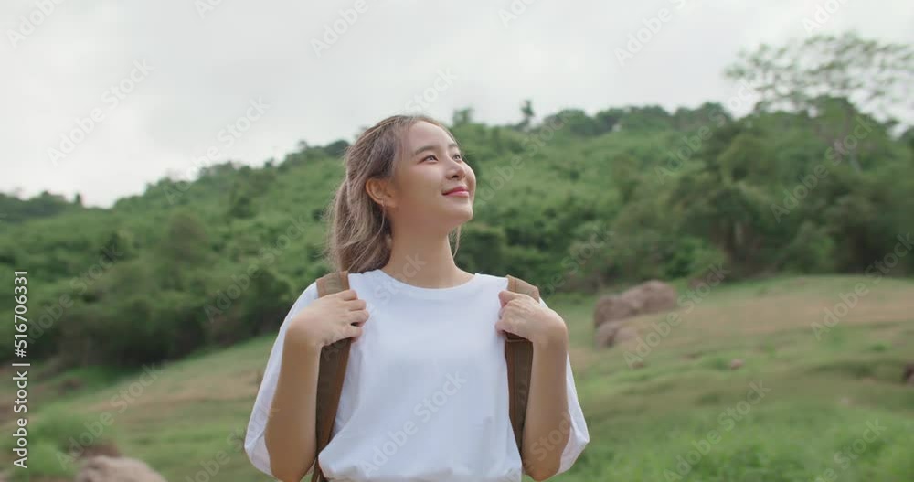 Shot move around Young asian woman with backpack enjoying beauty of summer nature in the mountains on sunny sky, breathing fresh air. Beautiful female explore tropical forest on holiday. Slow Motion. Shot move around Young asian woman with backpack enjoying beauty of summer nature in the mountains on sunny sky, breathing fresh air. Beautiful female explore tropical forest on holiday. Slow Motion.