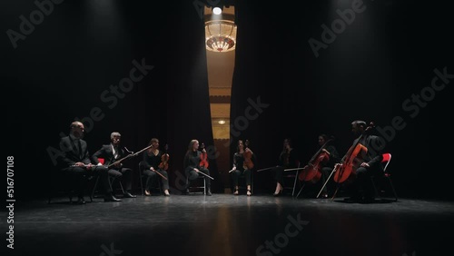musical band of cello, violin, bassoon and flute playing on scene of opera house, curtains opening