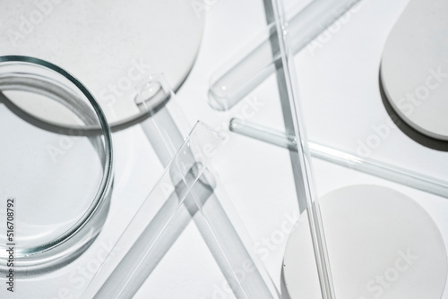 Test tubes, petri dish and glass rods in the laboratory on white background. Science research. Laboratory glassware close up. Transparent container. Medicine and beauty concept. photo