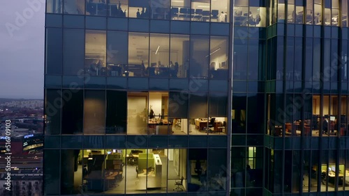 Drone shot of a skyscraper in the late evening with offices and workers. Aerial view of the facade of a skyscraper in the late evening and office windows in the International Business Center at night.