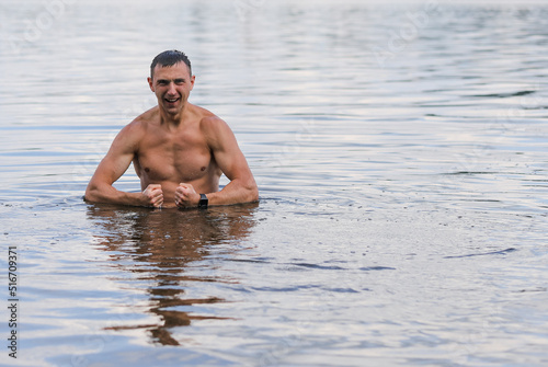 a handsome man is standing waist deep in water