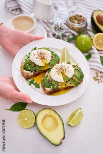 Freshly made poached egg and Avocado toasts on light grey background