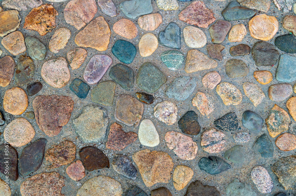 paved sidewalk with natural raw stones of different shapes and colors paved sidewalk with natural raw stones of different shapes and colors