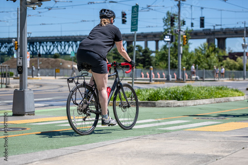 Overweight woman wants to lose weight and rides a bike on a bike path in a modern city