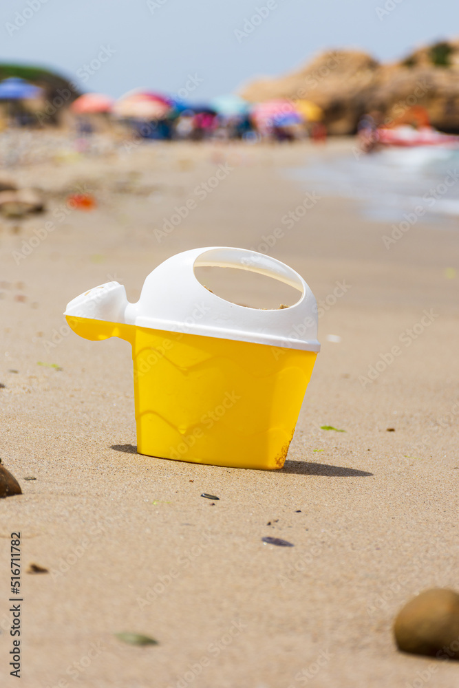 Yellow kid's plastic toy bucket on the beach. Yellow kid's plastic toy bucket on the beach.